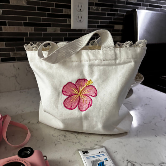 White bag with pink floral design on a marble countertop