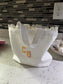 White lace-trimmed fabric with 'CG' initials on a tiled wall.